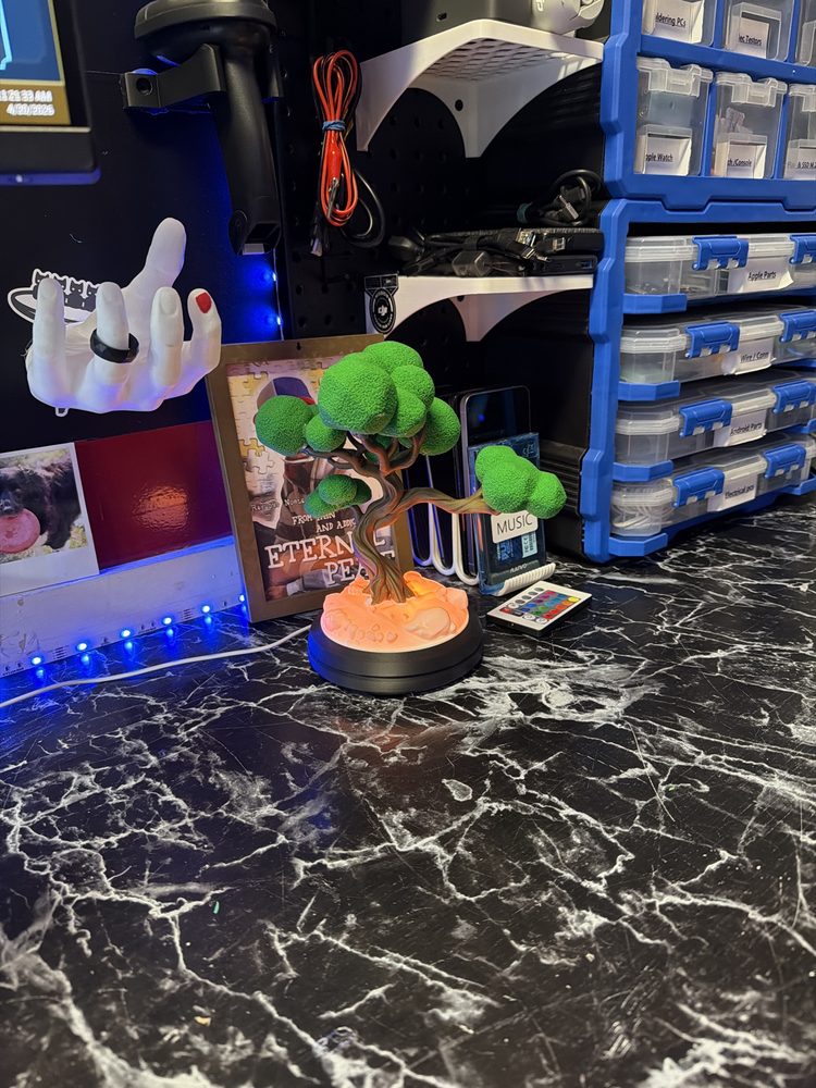 3D-printed bonsai tree lamp glowing on a workbench