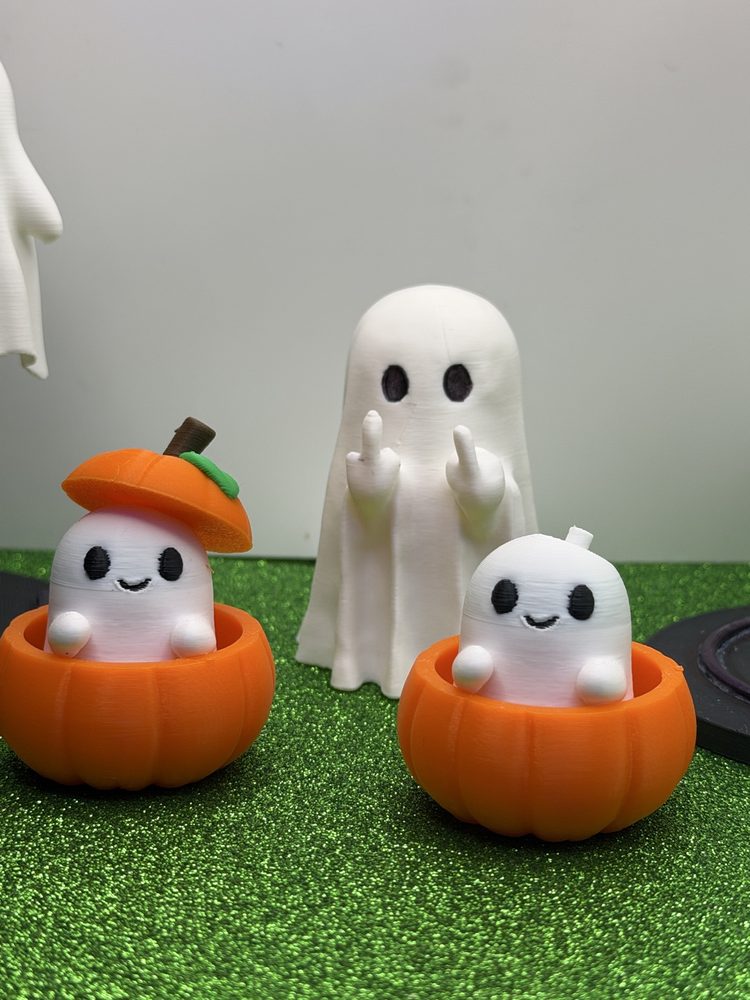Playful ghost figures sitting in pumpkins