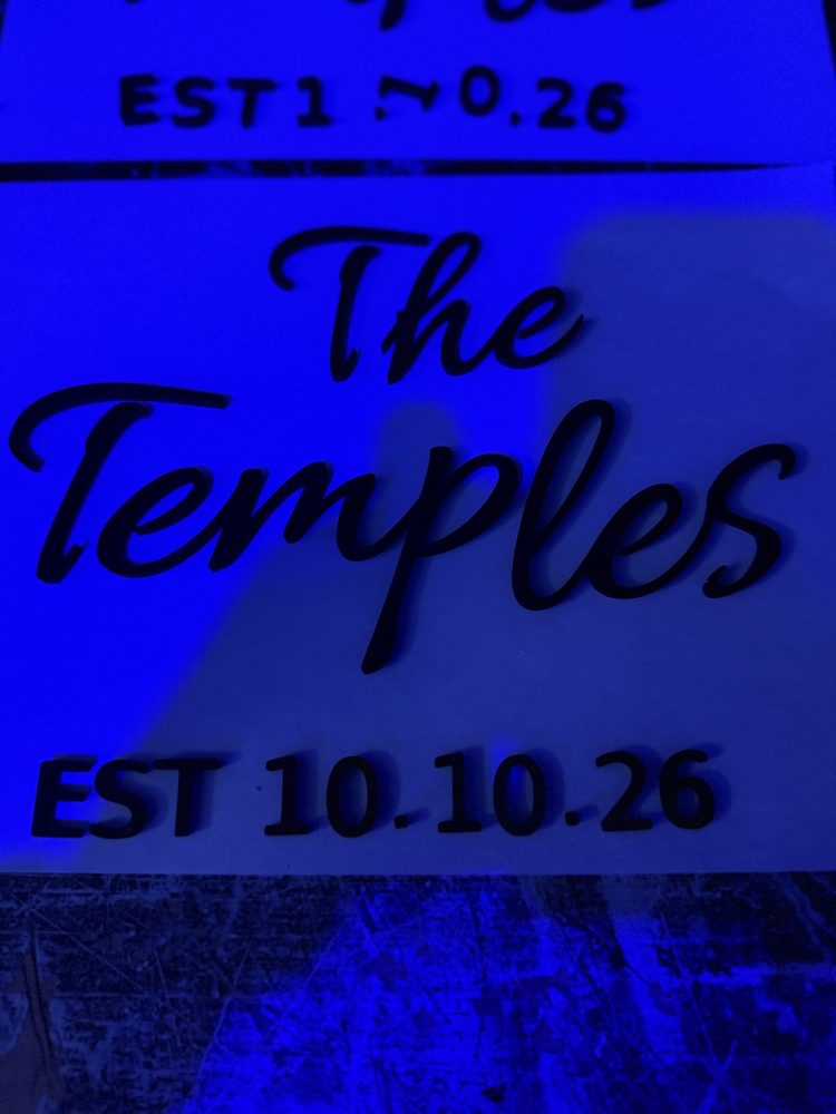 3D-printed The Temples EST 10.10.26 sign glowing under blue light