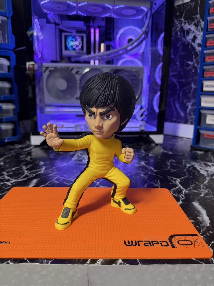 Bruce Lee figure in yellow tracksuit on a work mat