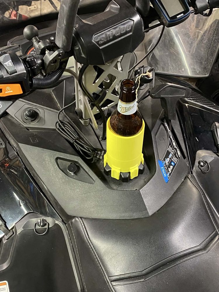 Yellow 3D-printed cup holder mounted on a Ski-Doo snowmobile holding a bottle